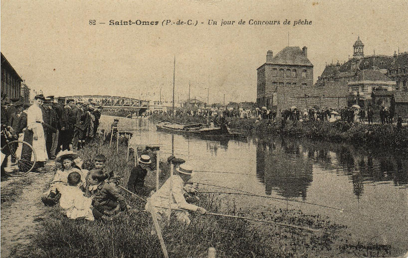 On voit ici un concours de pêche le long du canal, beaucoup de monde sur cette vue,les pêcheurs avec leur canotier sur la tête sont moins monbreux que les badauds,dans le fond on aperçoit le pont de la gare.